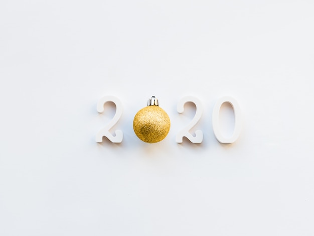 Fondo de año nuevo 2020 con balón de oro. Números 2020 en espacio de copia en blanco con bola decorativa para árbol de Navidad.