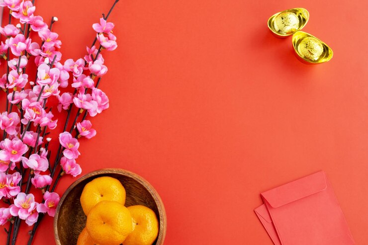 Foto fondo de año nuevo chino endecha plana flor de cerezo mandarina naranja sobre rojo y lingotes de oro sobre fondo rojo