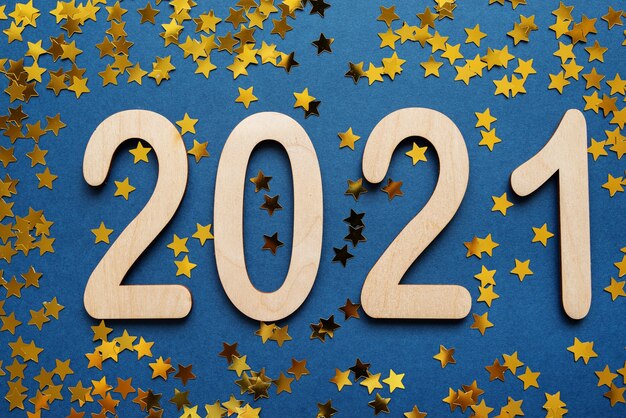 Fondo de año nuevo con números 2021 en azul con estrellas doradas.