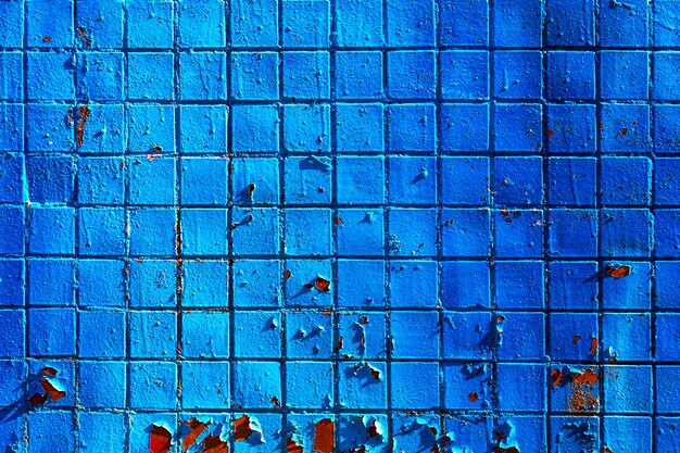 Fondo arquitectónico hecho de azul pintado mosaico pared con grietas