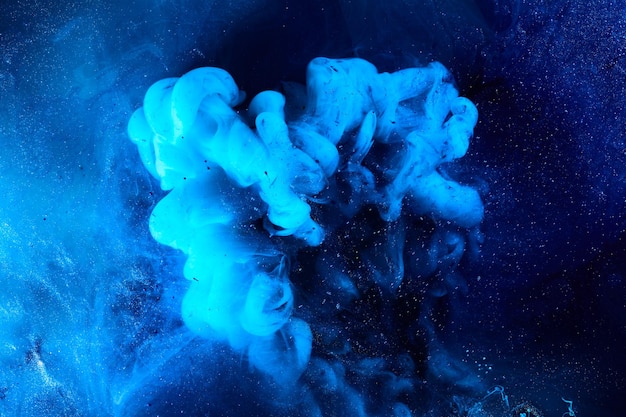 Fondo azul abstracto del océano Salpicaduras y olas de pintura bajo el agua nubes de humo en movimiento