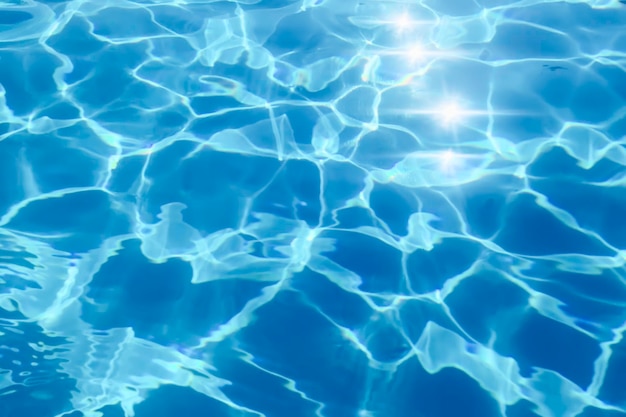 Fondo azul del agua de la ondulación, reflejo del sol del agua de la piscina