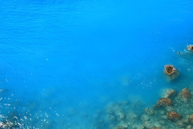 Fondo azul de aguas profundas con rocas mojadas