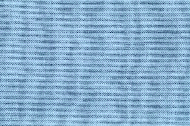 Fondo azul claro de un material textil con patrón de mimbre, primer plano.
