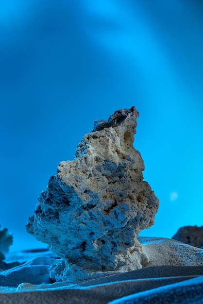 Fondo azul para exhibición de productos con hielo y arena.