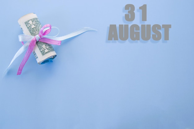 Fondo azul de fecha de calendario con billetes de dólar enrollados fijados por cinta rosa azul 31 de agosto