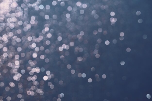 Fondo azul festivo de luces de brillo plateado Abstracción borrosa de invierno