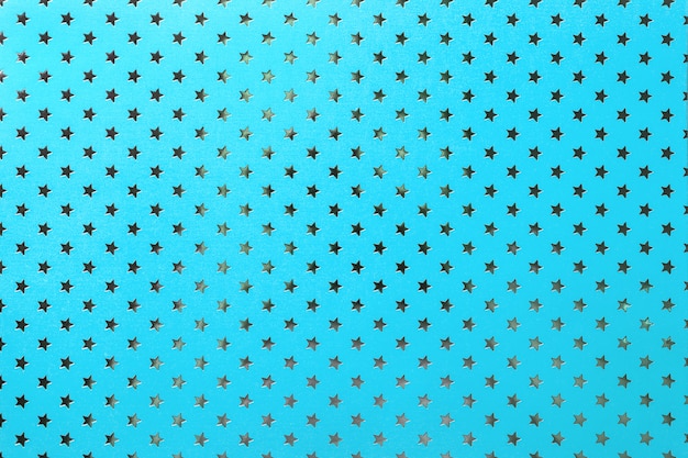 Fondo azul de papel de aluminio con un patrón de estrellas plateadas