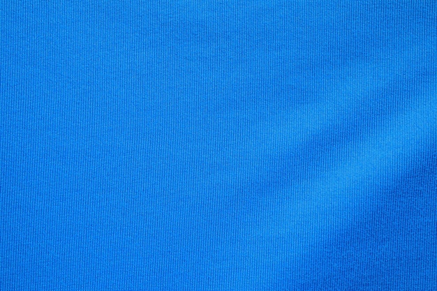 Fondo azul de la ropa de los deportes de la textura de la tela de la ropa de la camiseta de fútbol