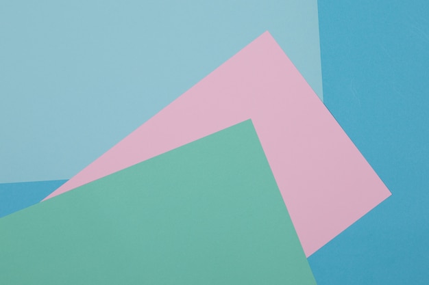 Fondo azul, verde y rosa, el papel de color se divide geométricamente en zonas, marco, copia, espacio.