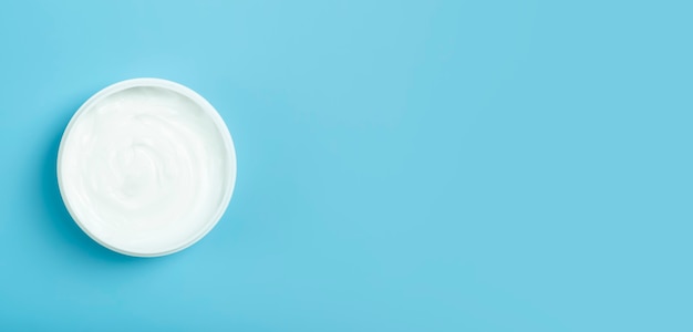 Fondo de banner de crema cosmética crema cosmética blanca para la piel y el cuerpo en un frasco blanco abierto