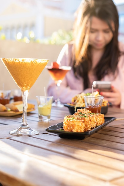 Fondo de bebidas multicolores y comida mínima Concepto de hora feliz con cócteles elegantes y sabrosos aperitivos servidos en el salón de la azotea Prive Focus on Glass