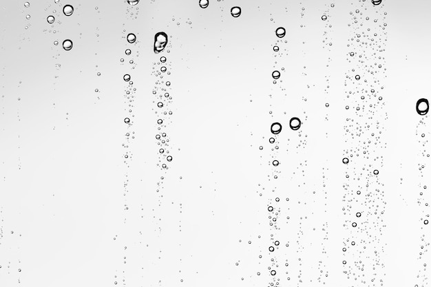 Fondo blanco aislado Gotas de agua sobre el vidrio / vidrio de la ventana mojada con salpicaduras y gotas de agua y cal, textura de fondo de otoño