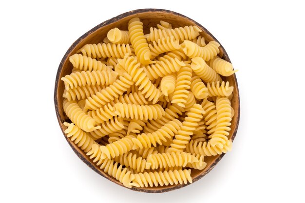 Fondo blanco aislado de pasta fusilli sin cocer.