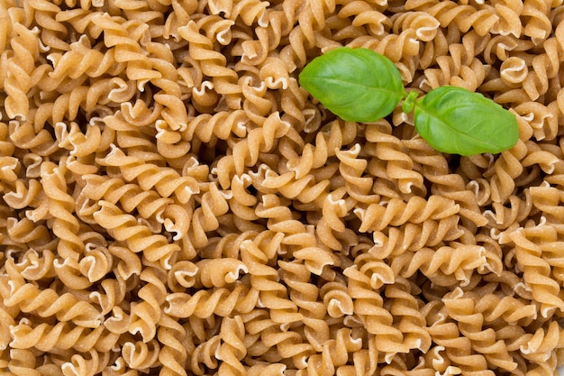 Fondo blanco aislado de pasta integral sin cocer.