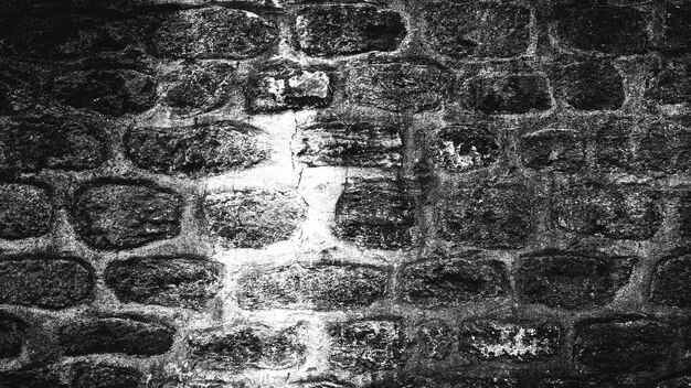 Fondo blanco y negro de la antigua muralla de piedra