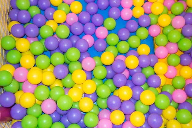 Fondo, bolas de colores de plástico de colores en el patio de recreo, piscina con bolas para el desarrollo y los juegos de los niños.