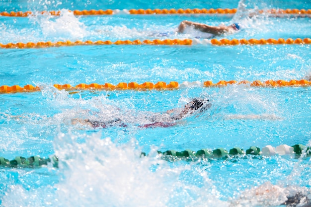 Fondo borroso del agua del descenso del chapoteo en raza de la natación.