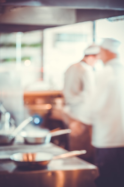 Fondo borroso: Grupo de chefs cocinando en la cocina