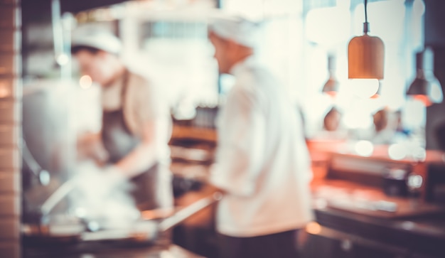 Fondo borroso: Grupo de chefs cocinando en la cocina