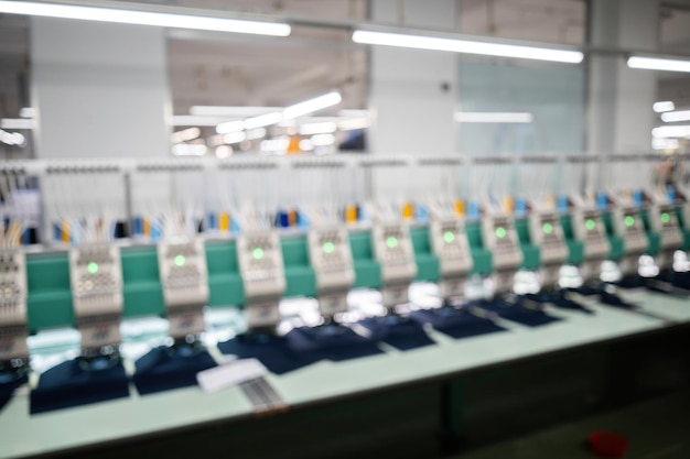 Fondo borroso Máquina de bordar moderna y automática de alta tecnología para textiles