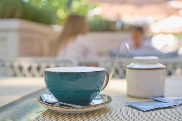 Fondo borroso una taza de café capuchino caliente en una mesa en un café con gente en el fondo Fondo retro vintage profundidad de campo hermosa abstracción bokeh para el fondo