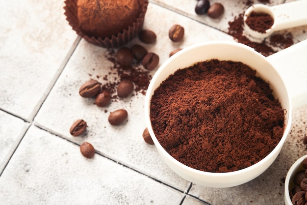 Fondo de café Cucharas de medición con taza de granos de café molidos y trufas de chocolate dulce en el fondo de la mesa agrietada de azulejos viejos Fondo de alimentos Vista superior con espacio para su texto