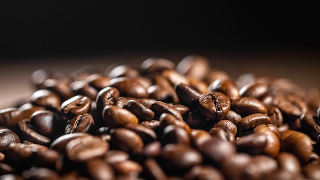 Fondo de café oscuro, fondo borroso con enfoque selectivo, textura de granos de café aromáticos