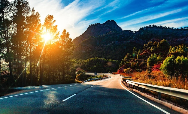 Fondo de carretera rural y colorido paisaje de puesta de sol. Viaje en coche y carretera escénica del desierto.