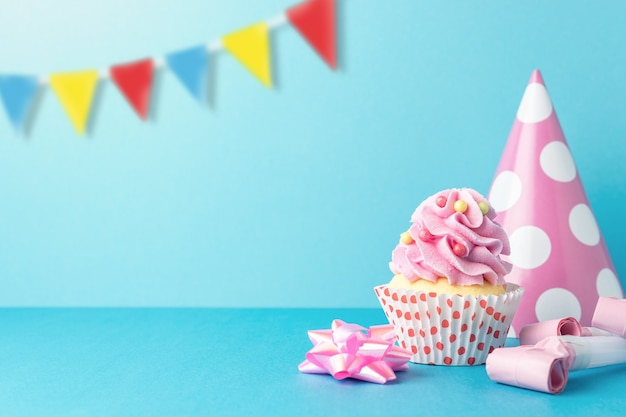 Fondo de celebración colorida con decoración de fiesta variada y cupcake.