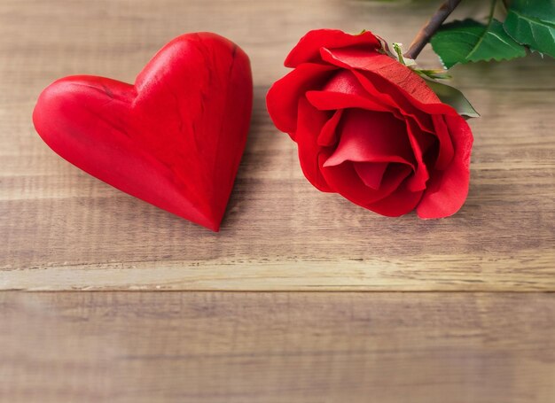 Foto fondo de la celebración del día de san valentín con champán, rosas en forma de corazón y caramelos rojos