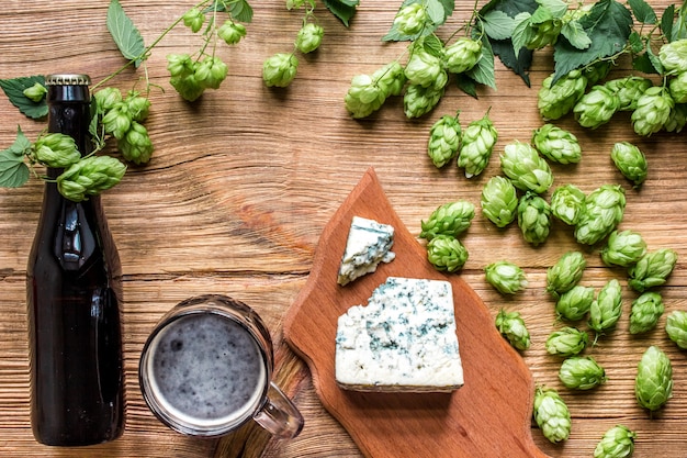 Fondo de cerveza Cerveza fresca y el queso salado en una mesa de madera. Vista superior