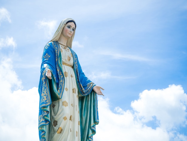 El fondo del cielo azul de la estatua de la Virgen María bendecida.