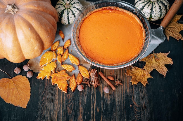 Fondo de cocción de otoño con pastel de calabaza calabaza hojas de otoño amarillas sobre fondo de madera