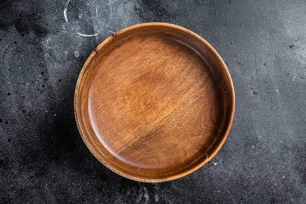 Fondo de cocina y alimentación saludable Plato de madera vacío en la mesa Fondo negro Vista superior Espacio de copia