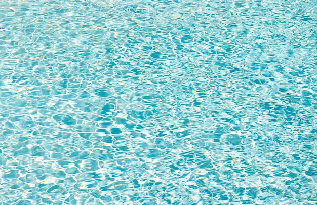 Fondo de color azul del agua de la piscina con ondas en el paraíso de verano