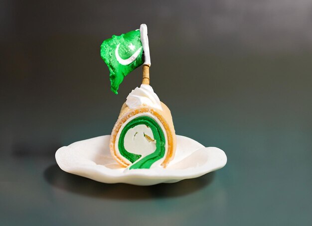 Foto en un fondo colorido, una mano con helado en forma de bandera de pakistán