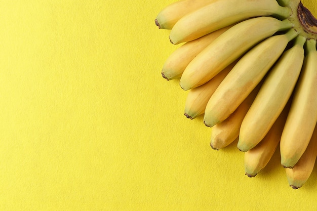 Fondo de la comida con la fruta del plátano en el papel amarillo.