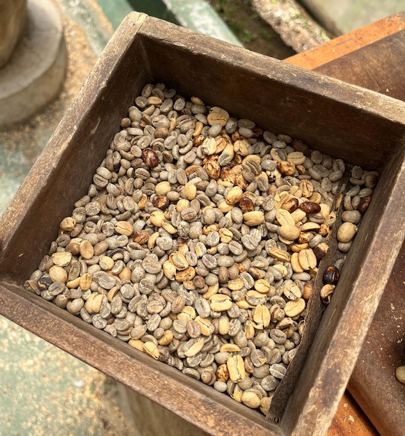 Fondo de comida con granos de café verdes sin tostar en una vieja caja de madera Vista superior