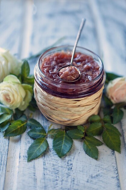 fondo de comida de mermelada de rosas con un frasco de vidrio lleno de té mermeladas de rosas