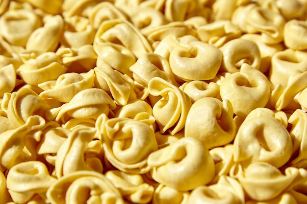 Fondo de comida de pasta tortellini Tortellini fresco con prosciutto crudo Pasta rellena italiana