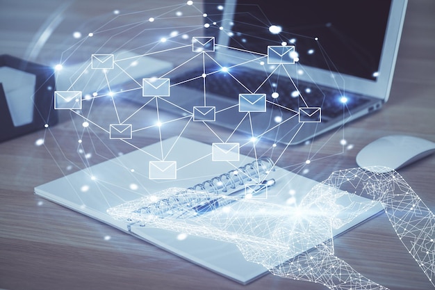 Fondo de computadora de escritorio en la oficina y sobres voladores dibujo holográfico de exposición múltiple concepto de correo electrónico