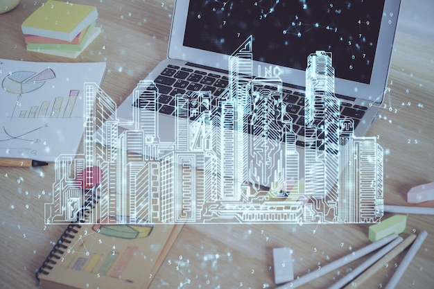 Fondo de computadora de escritorio en oficinas y edificios de la gran ciudad dibujo de holograma Doble exposición Concepto de ciudad inteligente