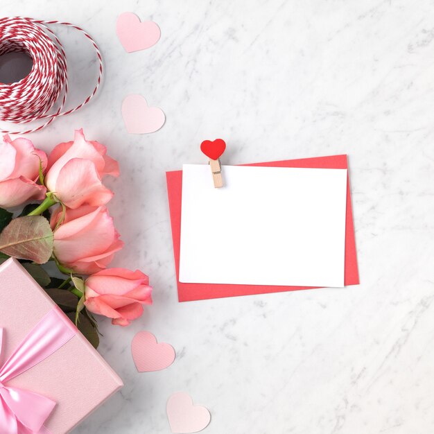 Fondo de concepto de diseño de San Valentín con flor rosa rosa, caja de regalo y tarjeta sobre fondo blanco de mármol