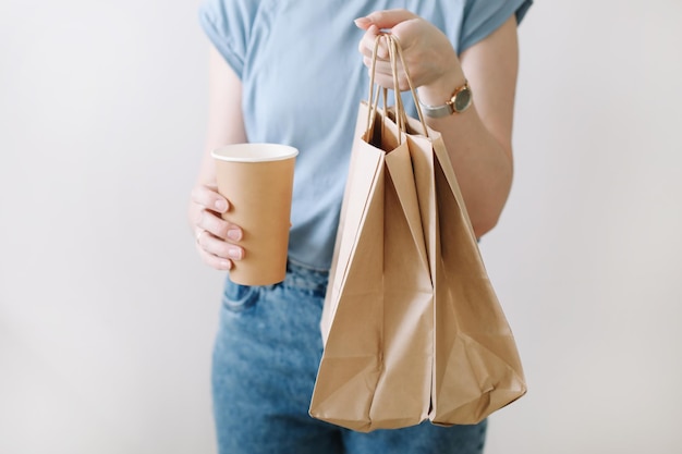 Fondo del concepto de entrega Manos de mujer sosteniendo bolsas de papel artesanales en banner de espacio de copia en blanco