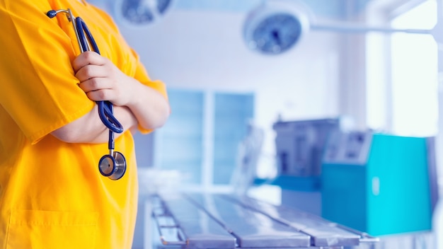 Fondo de concepto médico en uniforme amarillo en quirófano.