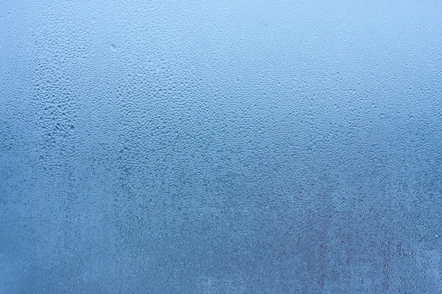 Fondo de condensación de gotas de agua de rocío en la humedad del vidrio y fondo en blanco brumoso Condensación en el vidrio de la ventana de metalplástico Fuera de la ventana mal tiempo lluvia