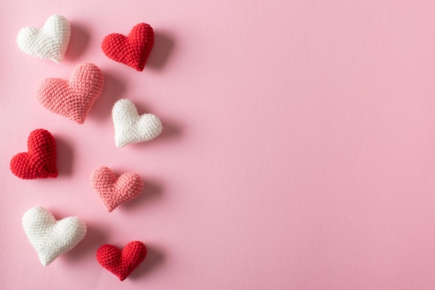 Fondo de corazones de punto sobre un fondo rosa claro para el Día de San Valentín