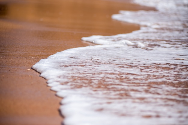 Fondo de la costa, las olas del mar y la arena