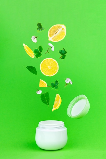 Foto fondo creativo con limones frescos y hojas verdes sobre fondo verde brillante.